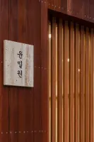 테라조 간판과 적갈색 우드 파사드 디테일